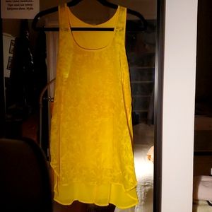 Flowy, yellow tunic. On the longer end, hits below the butt and slightly sheer!